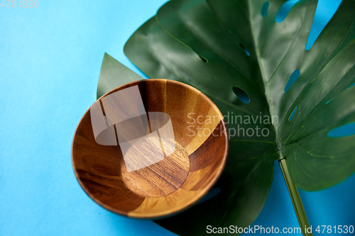 Image of close up of wooden plate and monstera leaf