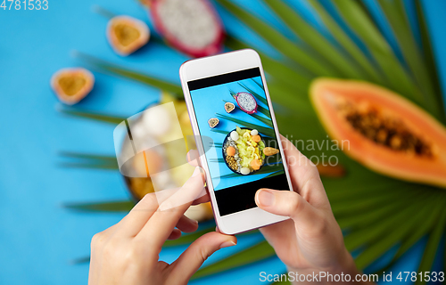 Image of hands taking photo of exotic fruits on smartphone