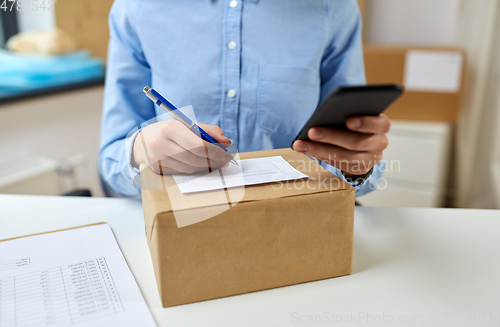 Image of close up of woman filling postal form at office