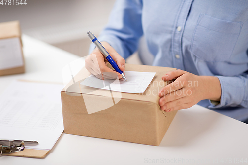 Image of close up of woman filling postal form at office