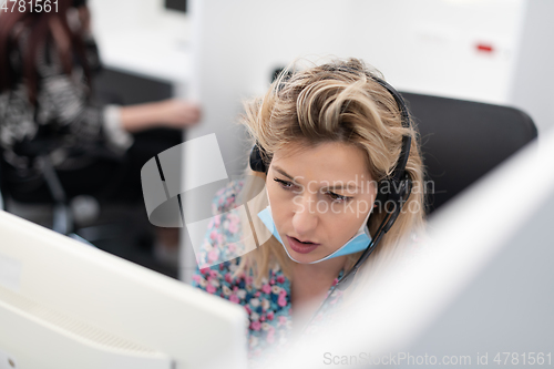 Image of call center operator in medical mask