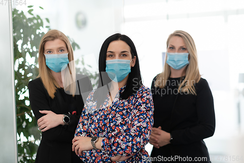 Image of business team in protective medical mask at modern office