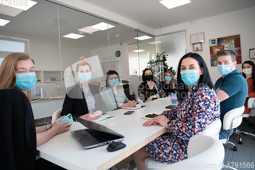 Image of real business people on meeting wearing protective mask