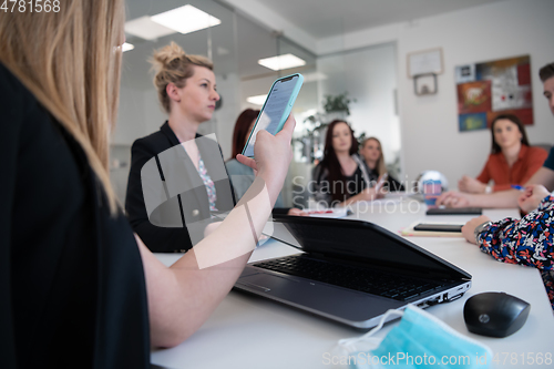 Image of business woman as team leader on meeting checking phone messages