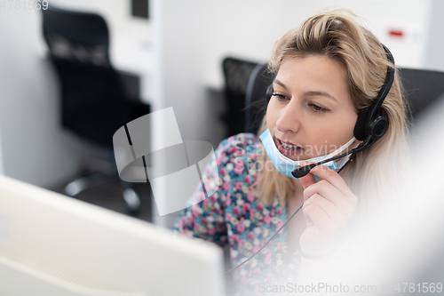 Image of call center operator in medical mask