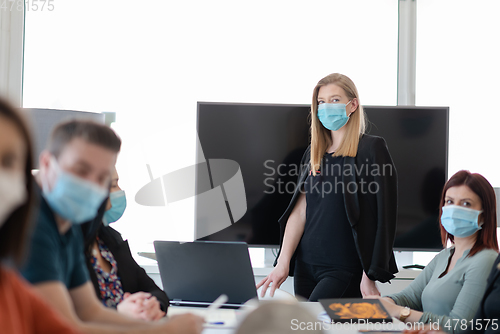 Image of real business people on meeting wearing protective mask