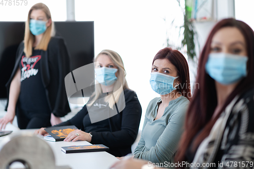 Image of real business people on meeting wearing protective mask