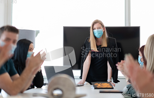 Image of real business people on meeting wearing protective mask