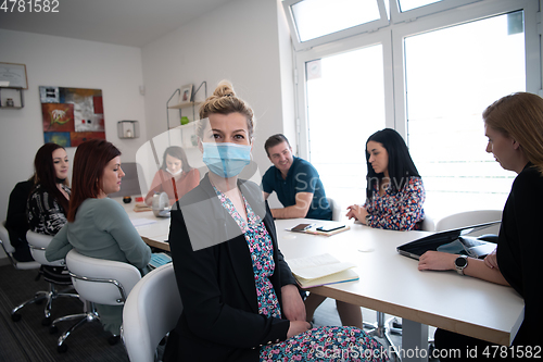 Image of real business people on meeting wearing protective mask