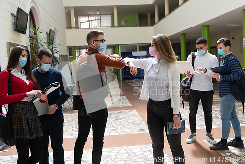 Image of students greeting new normal coronavirus handshake and elbow bumping