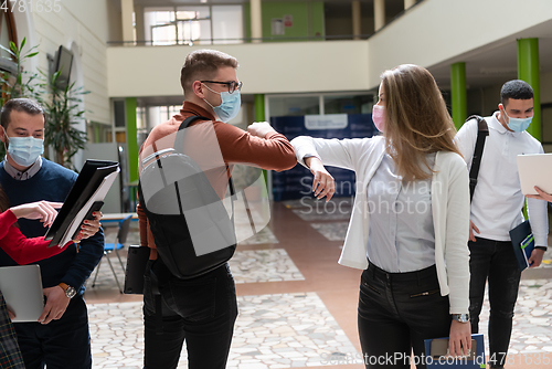 Image of students greeting new normal coronavirus handshake and elbow bumping