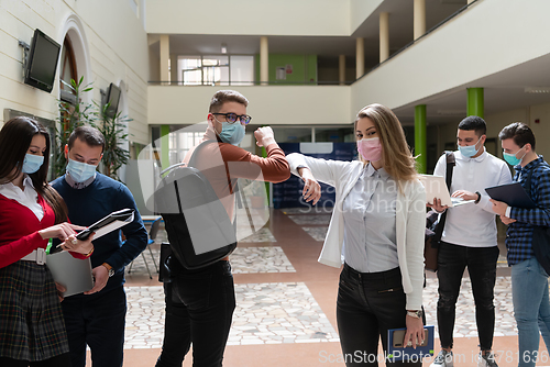 Image of students greeting new normal coronavirus handshake and elbow bumping