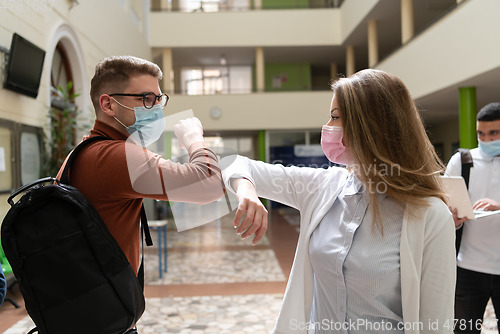 Image of students greeting new normal coronavirus handshake and elbow bumping