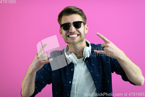 Image of guy wears glasses and headphones while dancing and having fun