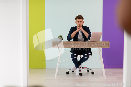 Image of Smiling young man freelancer using laptop studying online working from home