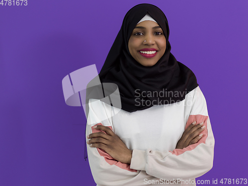 Image of portrait of african muslim woman wearing hijab and traditional muslim clothes posing in front of purple background