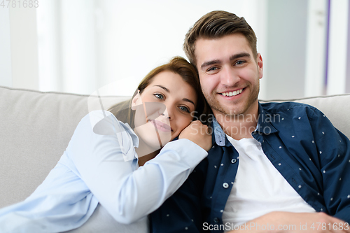 Image of young couple watching tv at home in bright living room