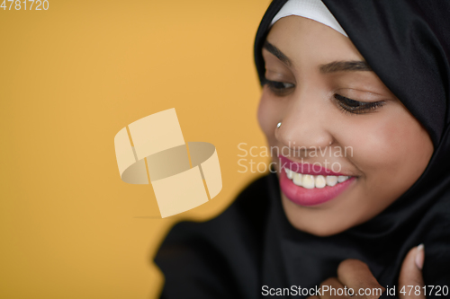 Image of african muslim woman with a beautiful smile takes a selfie with a cell phone