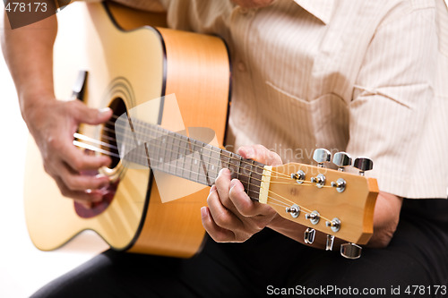 Image of Senior man playing guitar