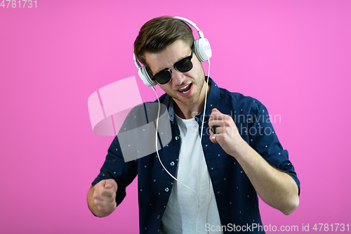 Image of guy wears glasses and headphones while dancing and having fun