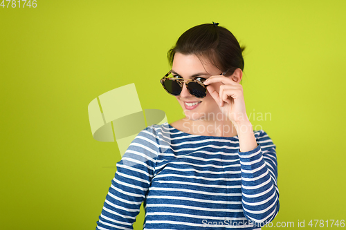 Image of woman in sunglasses posing in front of a green background