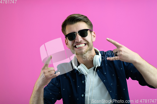 Image of guy wears glasses and headphones while dancing and having fun