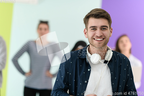 Image of guy with the beautiful smile in the blue attractive shirt i use my cell phone and headphones