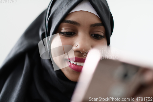 Image of afro girl uses a cell phone and browses social media during a pandemic