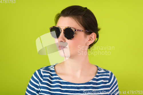 Image of woman in sunglasses posing in front of a green background