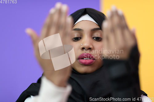 Image of african muslim woman wearing hijab and traditional muslim clothes posing in front of green background