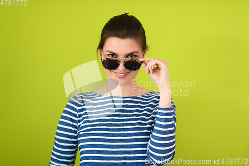 Image of woman in sunglasses posing in front of a green background