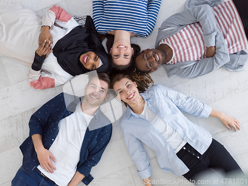 Image of top view of a diverse group of people lying on the floor and symbolizing togetherness