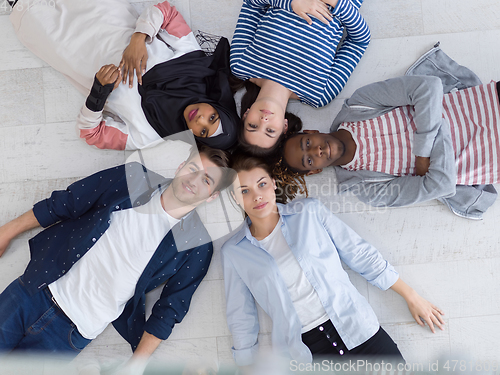 Image of top view of a diverse group of people lying on the floor and symbolizing togetherness