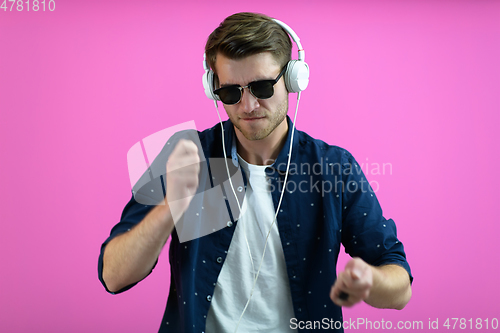 Image of guy wears glasses and headphones while dancing and having fun