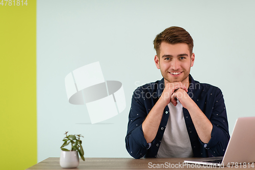 Image of Smiling young man freelancer using laptop studying online working from home