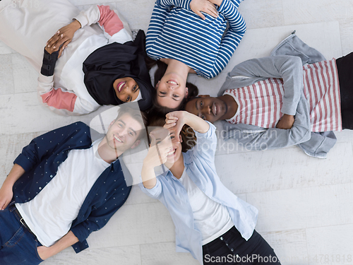 Image of top view of a diverse group of people lying on the floor and symbolizing togetherness