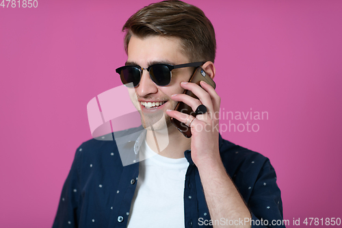 Image of a young man wearing a blue shirt and sunglasses using a smartphone