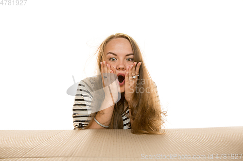 Image of Young woman opening the biggest postal package isolated on white