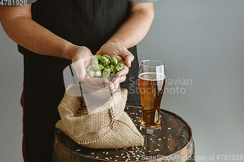 Image of Close up of confident young man brewer with self crafted beer