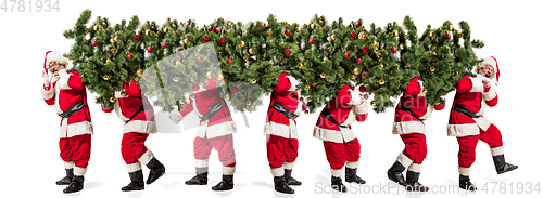 Image of Happy Christmas Santa Claus carrying a big Christmas tree
