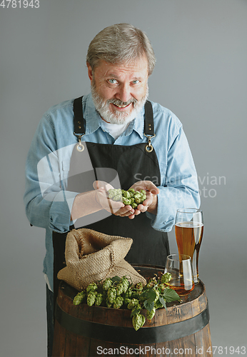 Image of Confident senior man brewer with self crafted beer