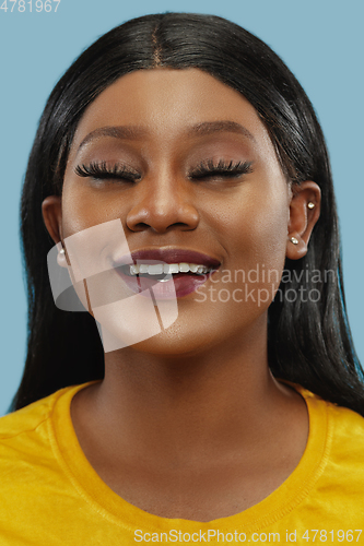 Image of African-american young woman\'s close up portrait on studio background