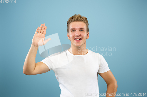 Image of Caucasian young man\'s half-length portrait on blue background
