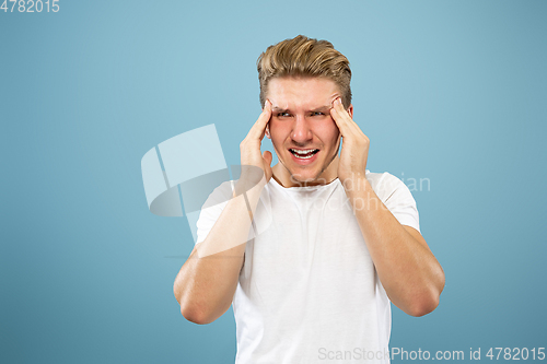 Image of Caucasian young man\'s half-length portrait on blue background