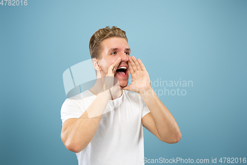 Image of Caucasian young man\'s half-length portrait on blue background