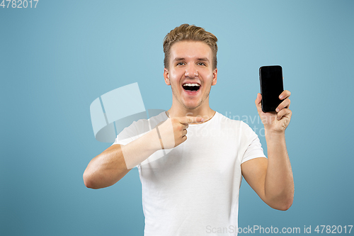 Image of Caucasian young man\'s half-length portrait on blue background