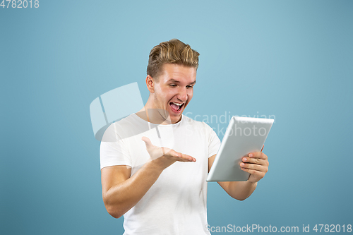 Image of Caucasian young man\'s half-length portrait on blue background