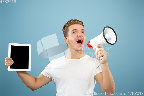Image of Caucasian young man\'s half-length portrait on blue background