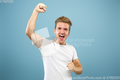 Image of Caucasian young man\'s half-length portrait on blue background