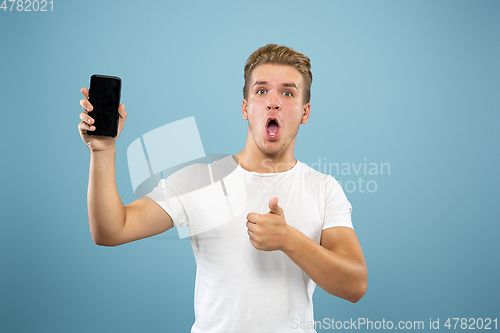 Image of Caucasian young man\'s half-length portrait on blue background